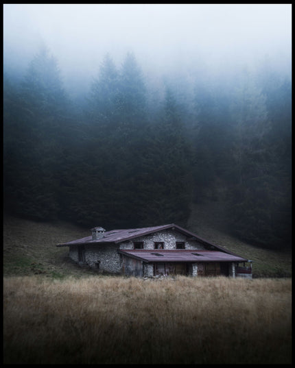 Ein Poster von einer einsamen Hütte im Nebel, umgeben von hohen Bäumen.