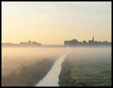 Ein Poster von einer nebligen Landschaft in den Niederlanden, mit einem Wasserkanal und einer Kirche im Hintergrund.