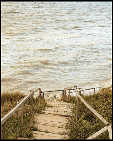 Ein Poster von einer Holztreppe die durch Dünen runter zum Strand führt.