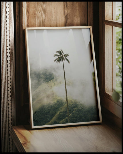 Ein gerahmtes Poster von einer hohen Palme im Nebel, vor einem Fenster an die Wand angelehnt